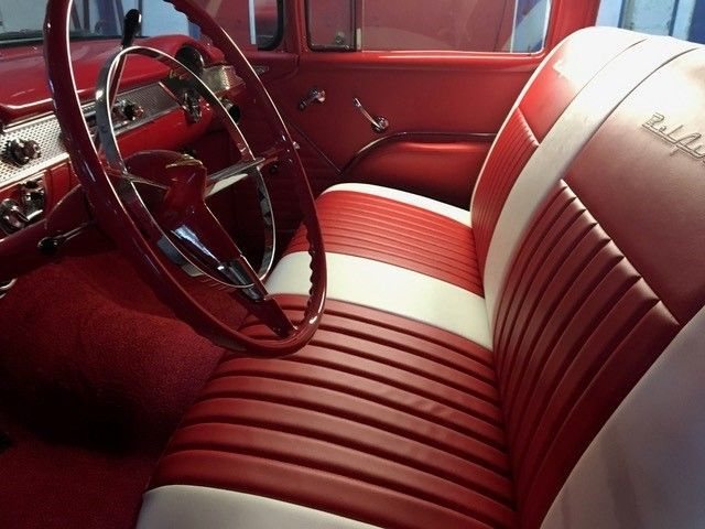Restored red and white classic Chevrolet interior with rolled and pleated bench seat